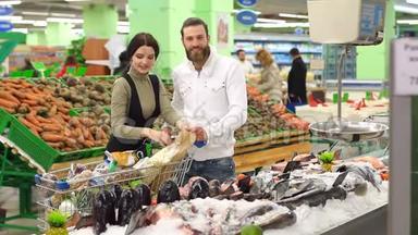 夫妇在超市里选择冷冻海鲜作为晚餐。